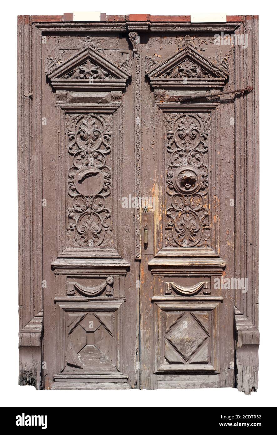 A very old archaic wooden door and frame is painted brown. Stock Photo