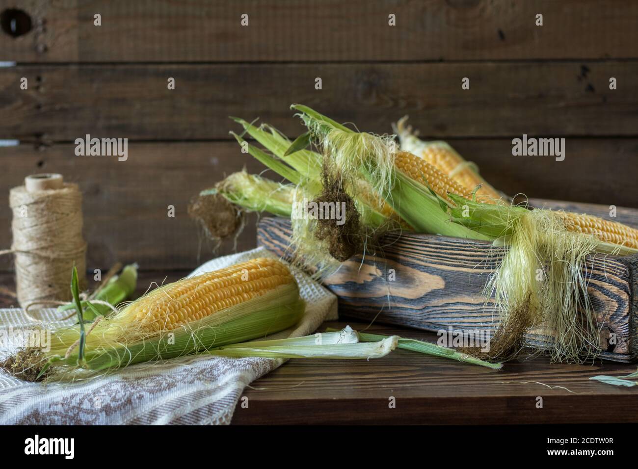 Fresh sweet corn on cobs on rustic wooden table Stock Photo