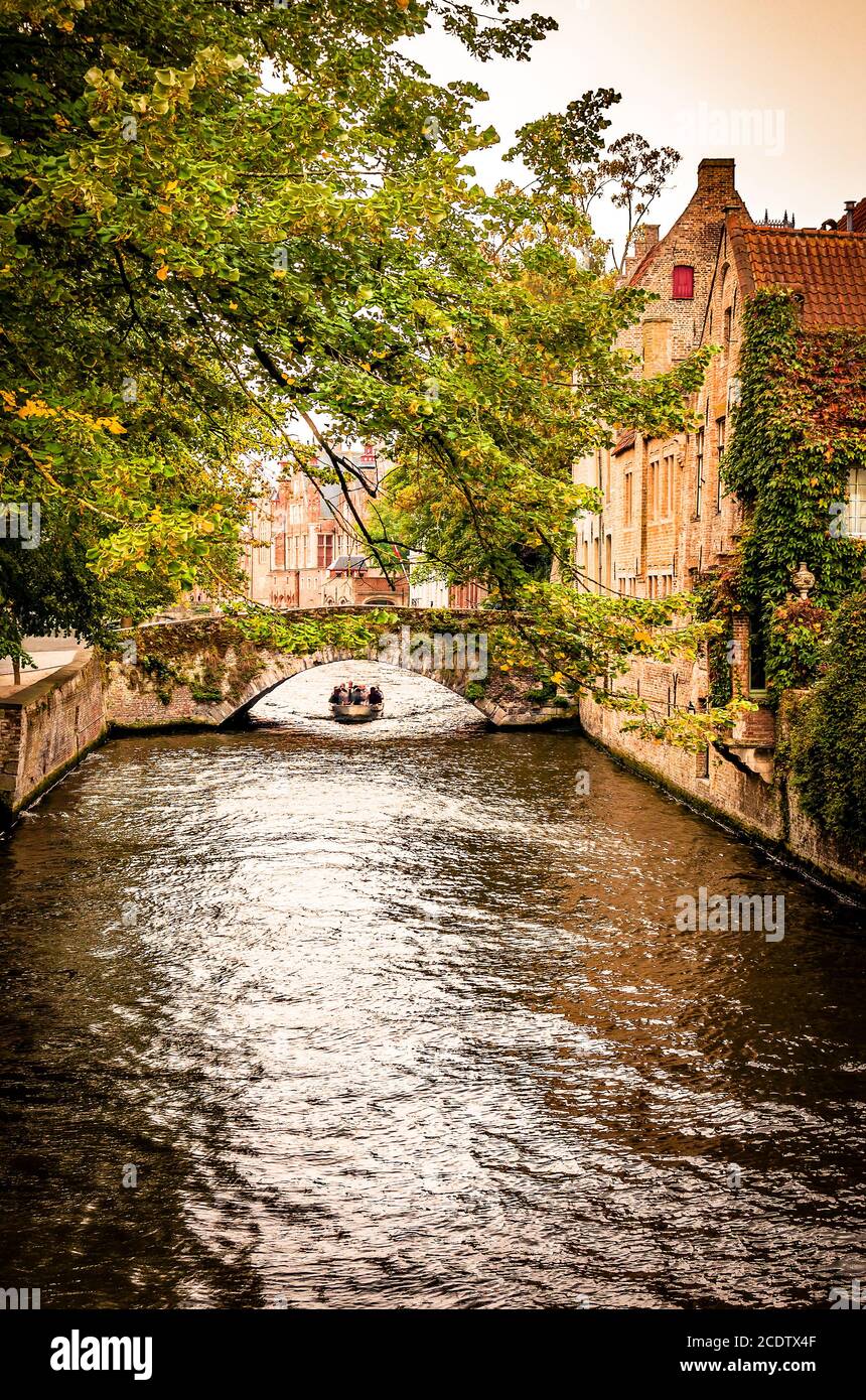 View of the Bruges Groenerei with canal boat, bridge and historic buildings Stock Photo