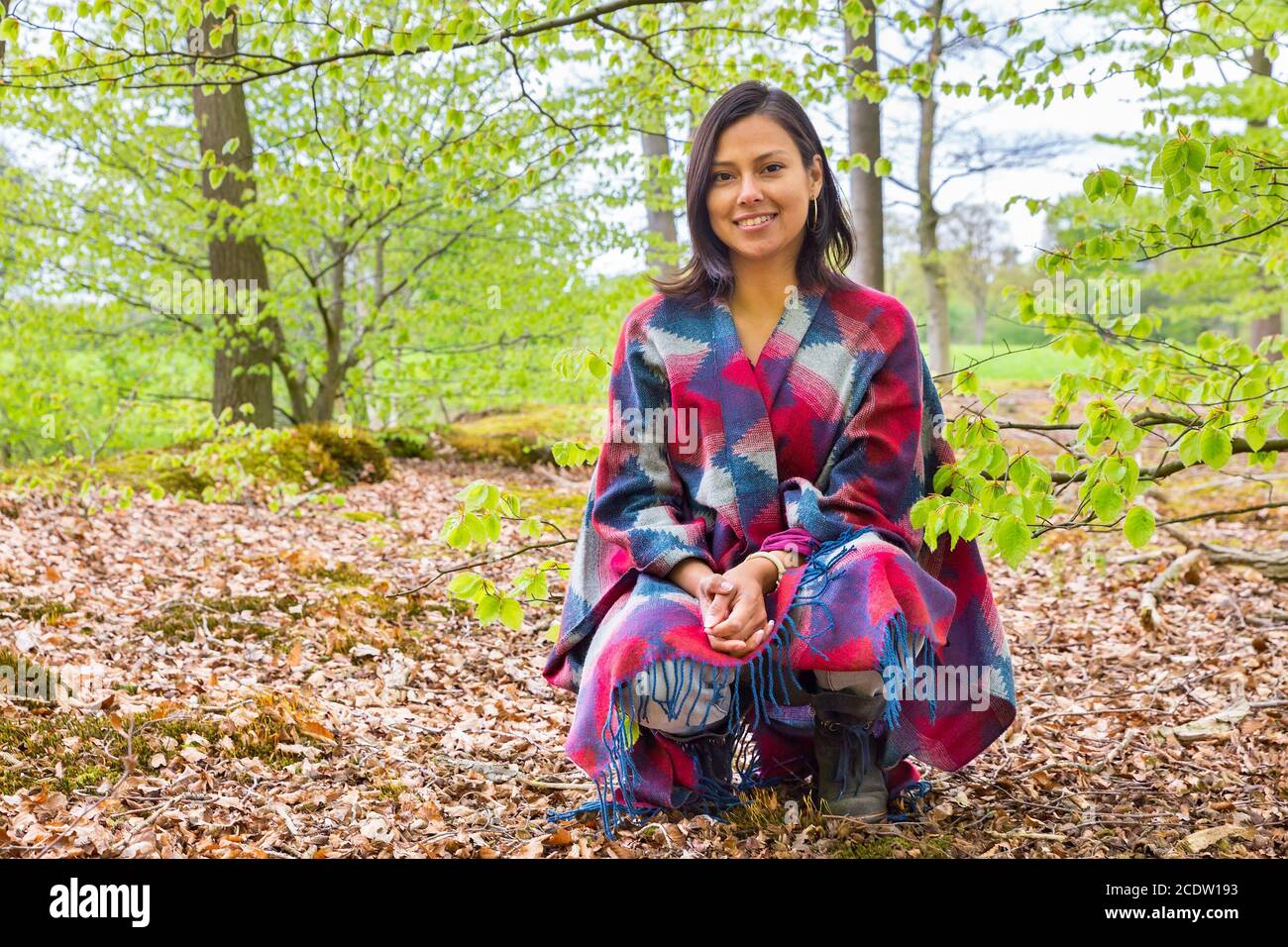 Young woman sitting in spring forest Stock Photo