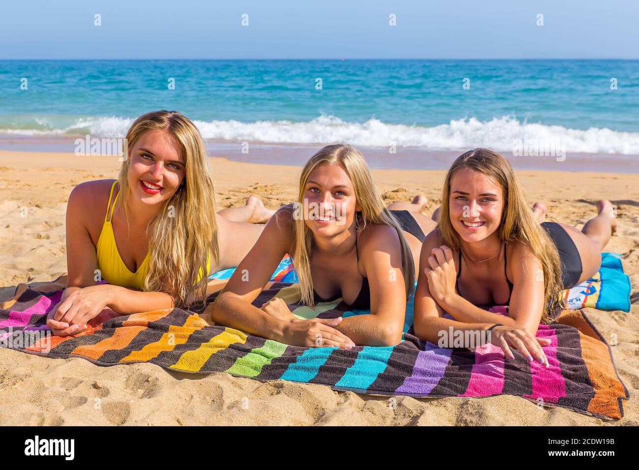 Three young european women sunbathing on beach Stock Photo