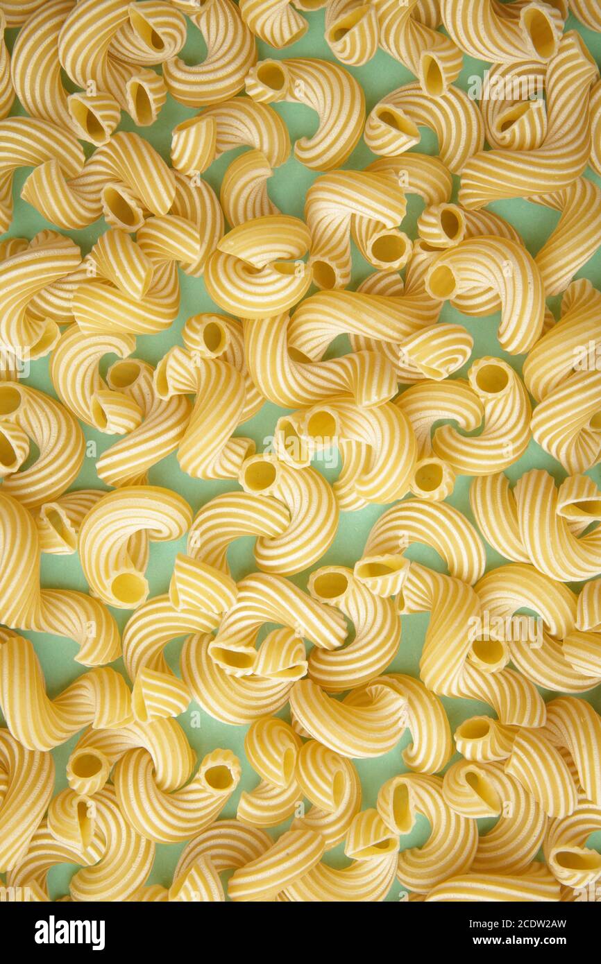 background of pasta in the form of tubes spun in a spiral Stock Photo