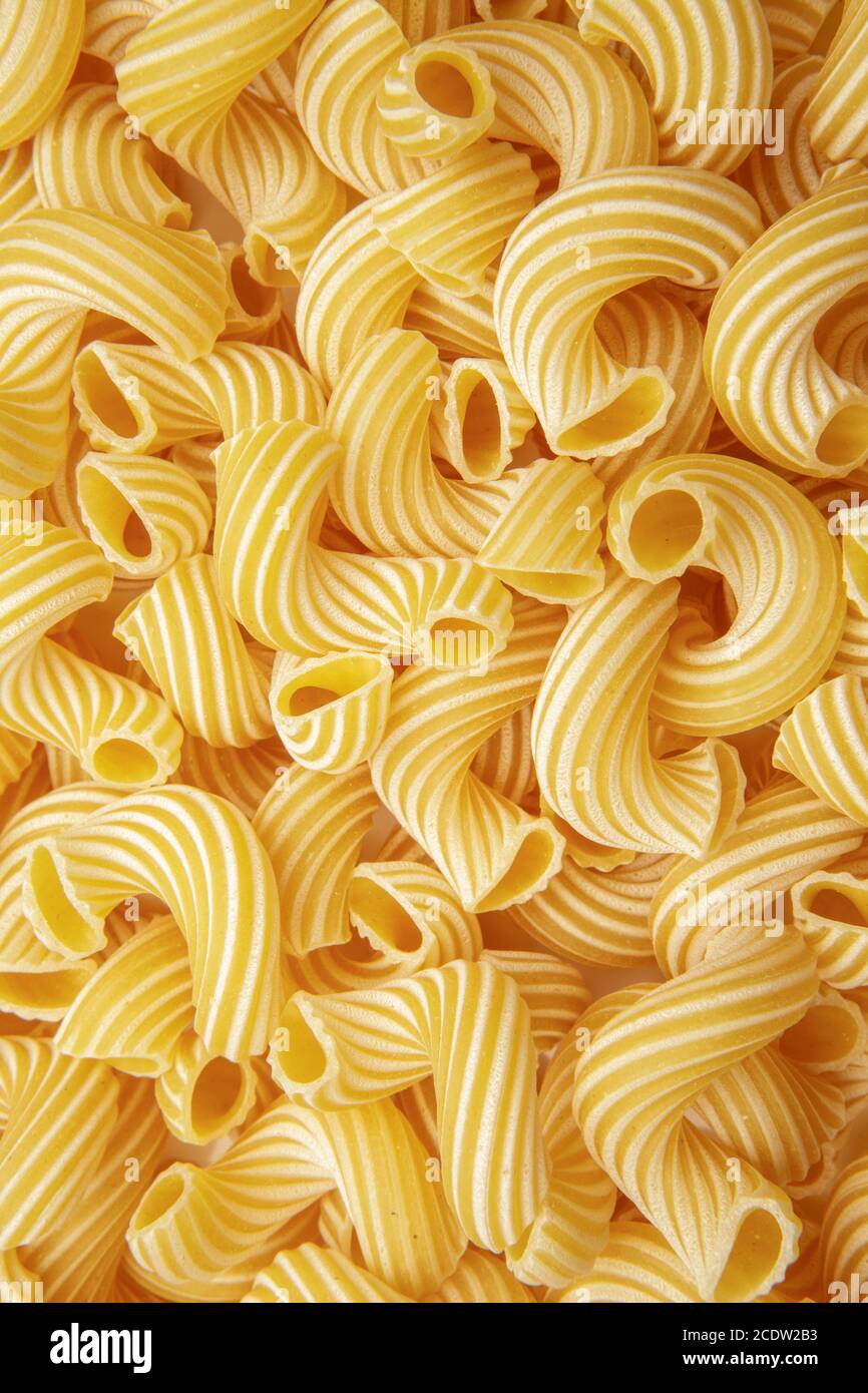 background of pasta in the form of tubes spun in a spiral Stock Photo