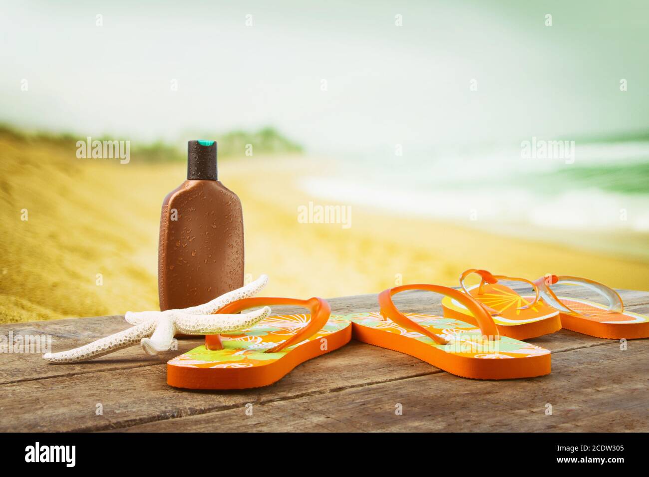 Sunbathing accessories placed on wooden planks at the beach Stock Photo
