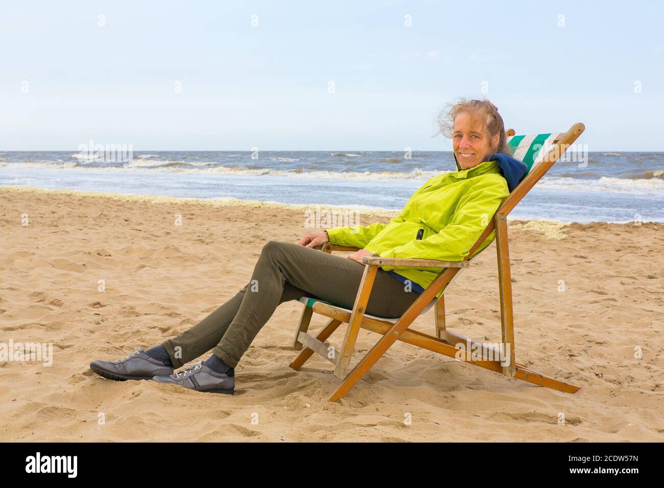 Dutch woman sits in beach chair by the sea Stock Photo