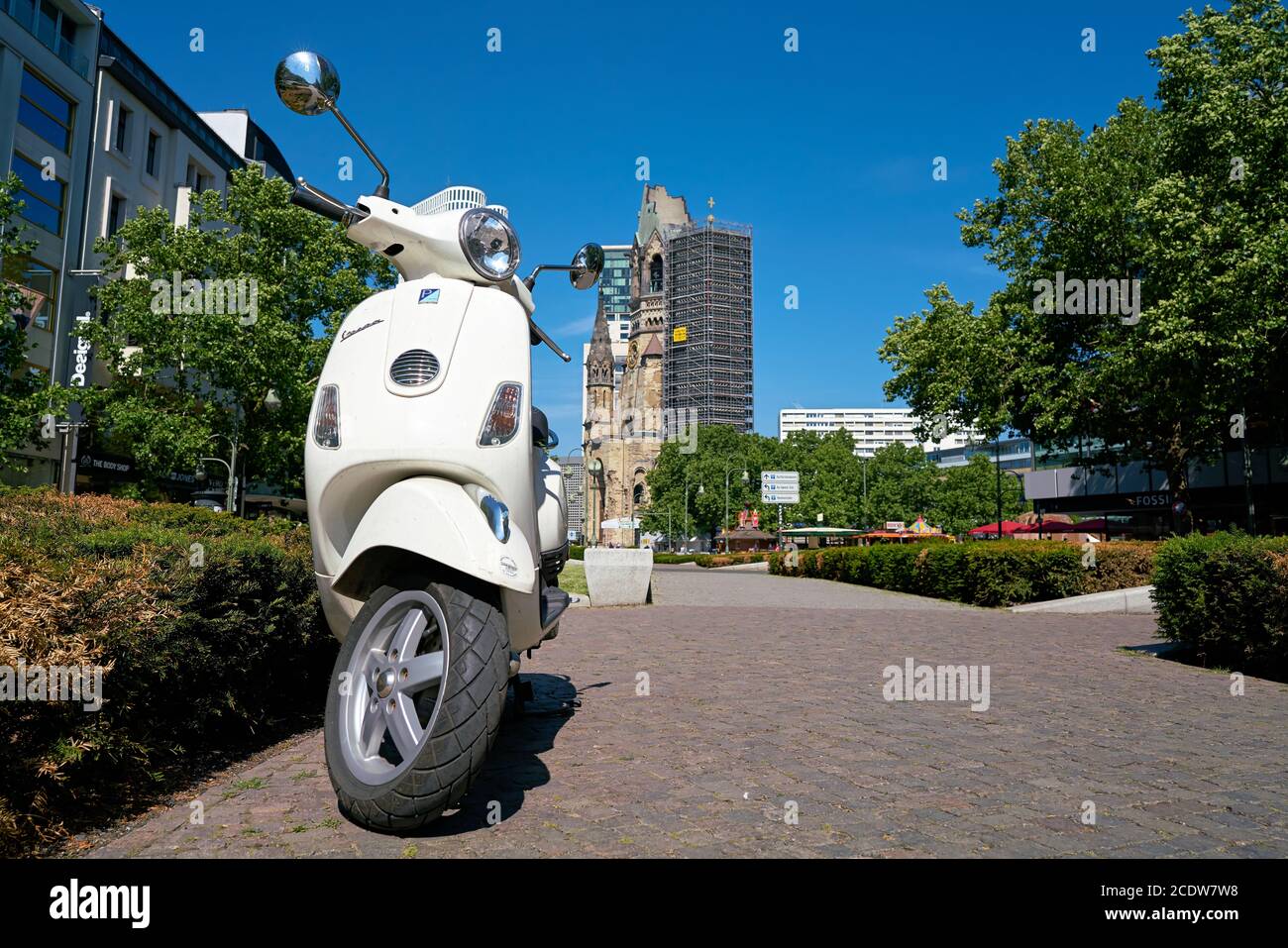 Parked scooter in downtown Berlin. In the background, the Breitscheidplatz is the Memorial Church. Stock Photo