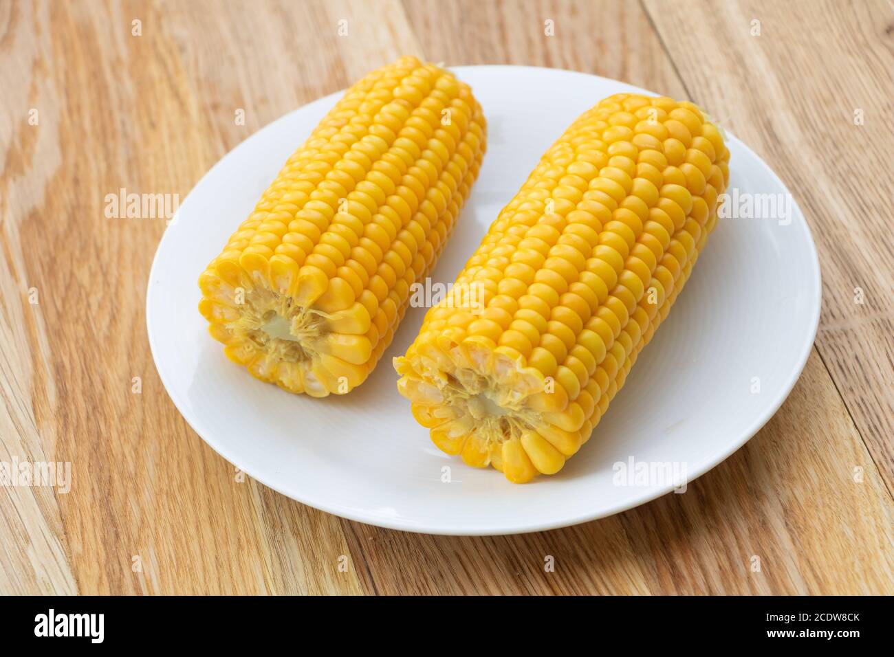 Freshly boiled corn on wooden background. Corn health benefits Stock