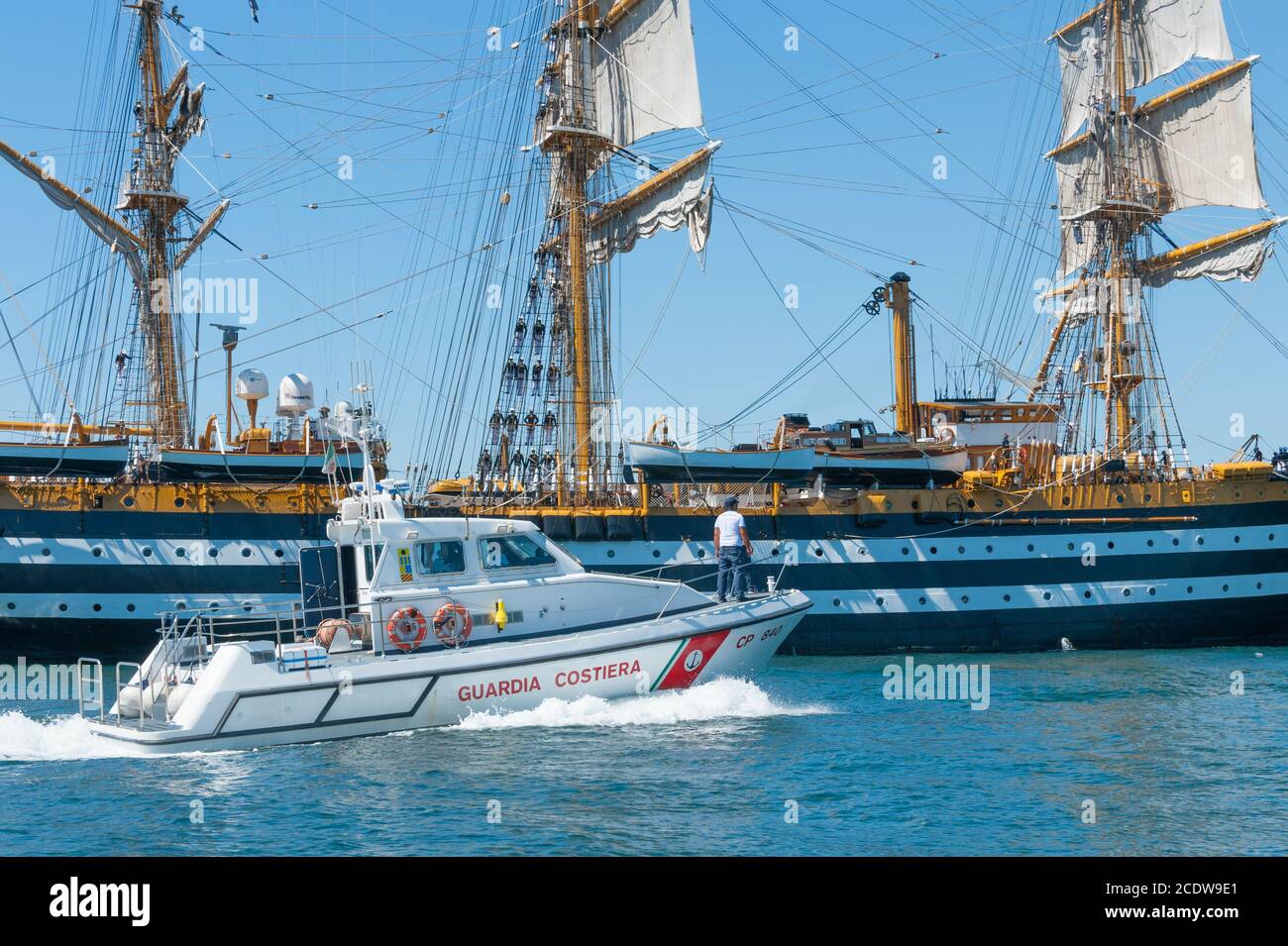 Patrol boat approach the training ship of the Italian Navy 'AMERIGO VESPUCCI' in the harbour of Taranto, Italy Stock Photo