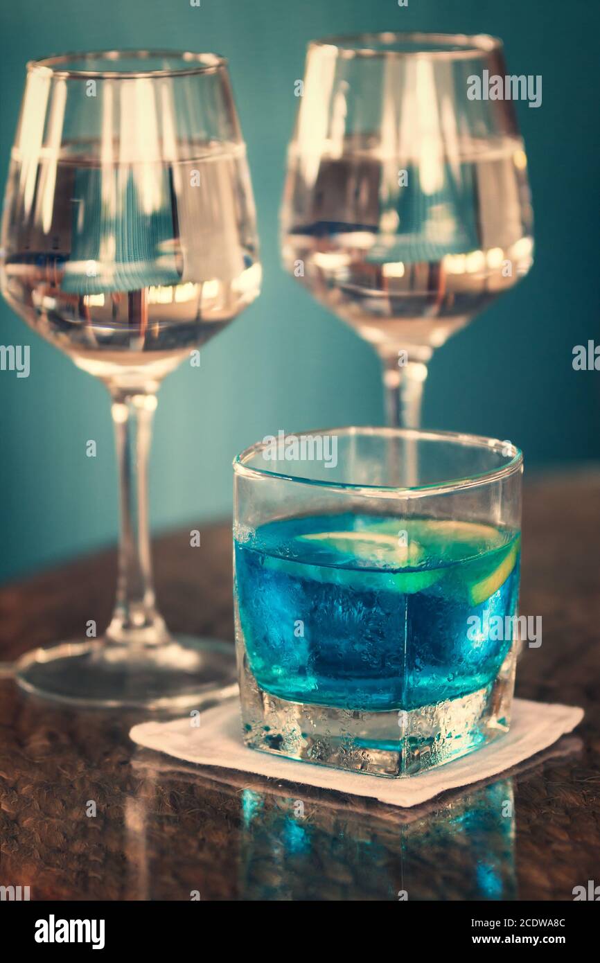 Long drink with blue curacao and two glasses of rosé wine Stock Photo