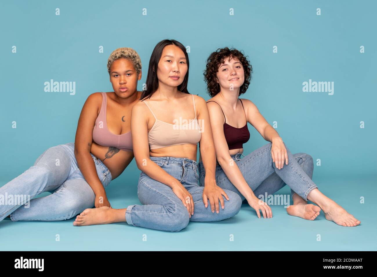 Three young contemporary females of Asian, Caucasian and African ethnicities Stock Photo