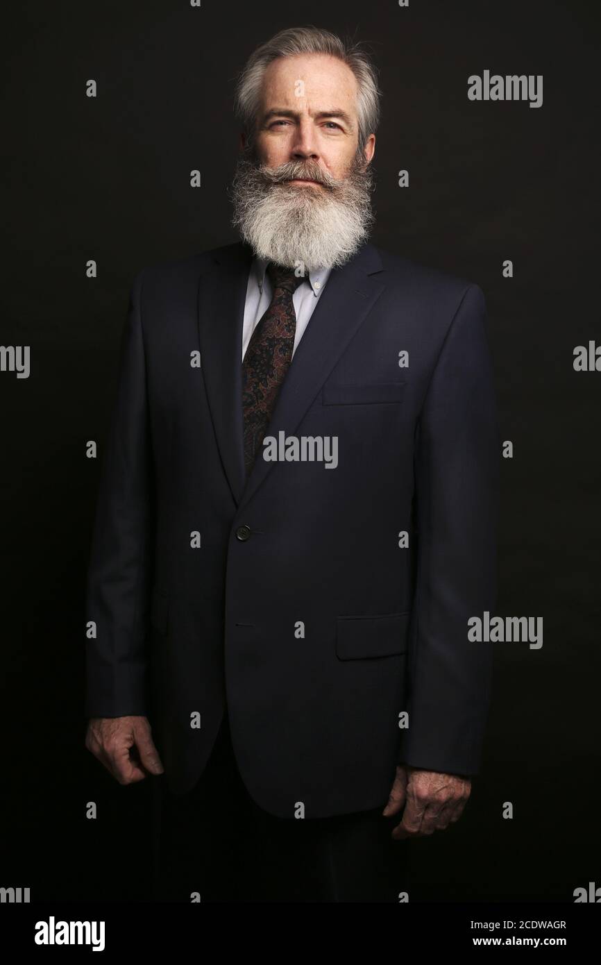 mature male model wearing suit with grey hairstyle and beard Stock Photo