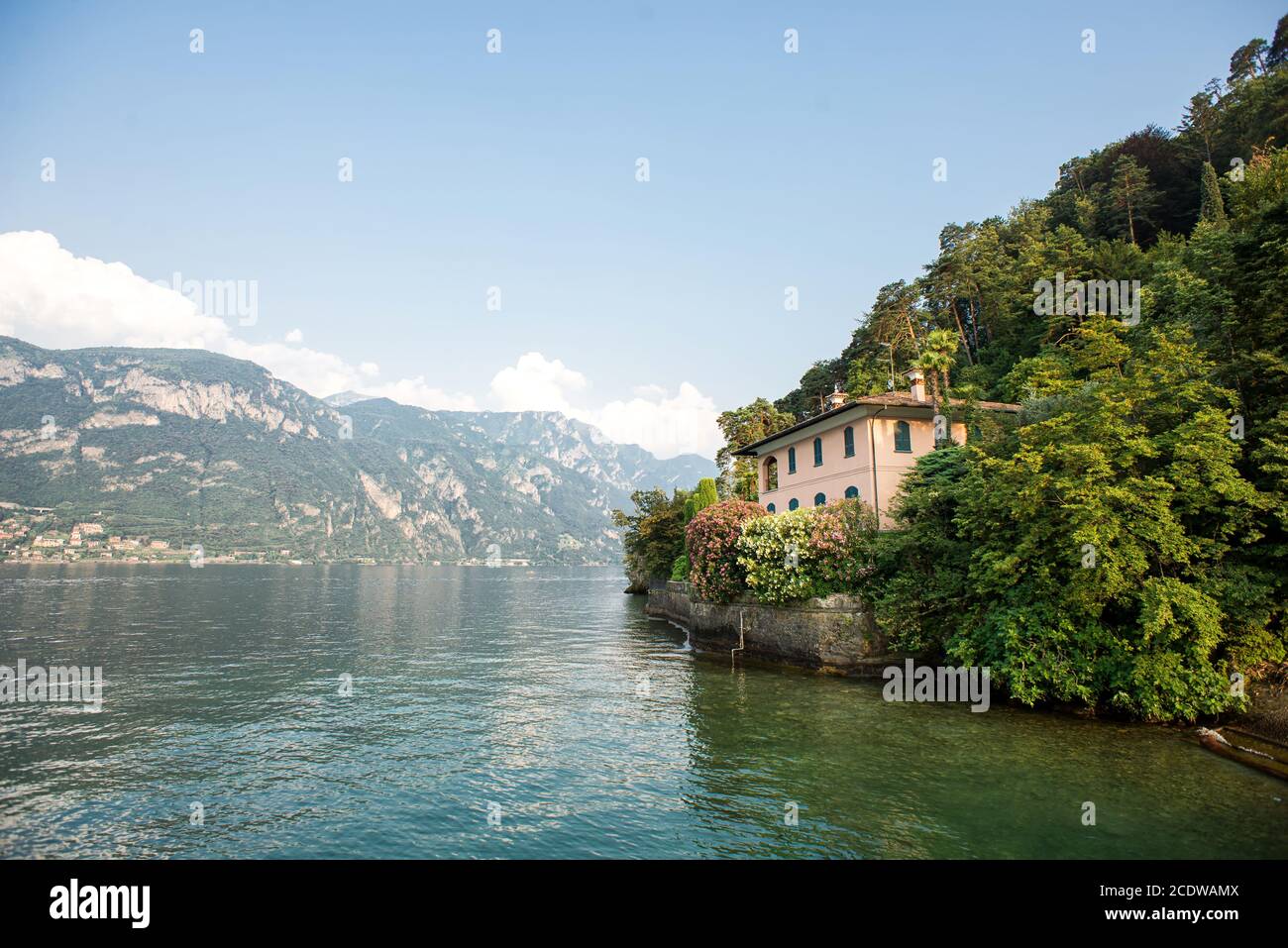 Bellagio. Lake Como. Italy - July 19, 2019: Stunning Landscape with Alps and Lake Como. Old Villa on Shore Among Trees. Stock Photo