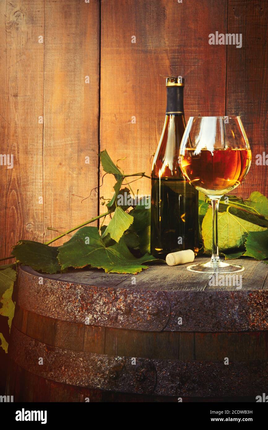 White wine bottle and glass on old barrel Stock Photo