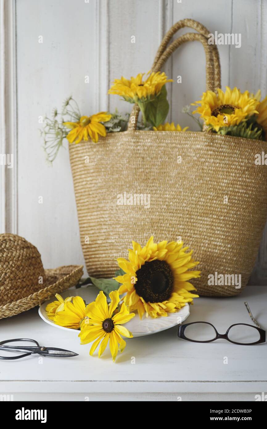 Closeup of sunflowers in straw purse on table Stock Photo