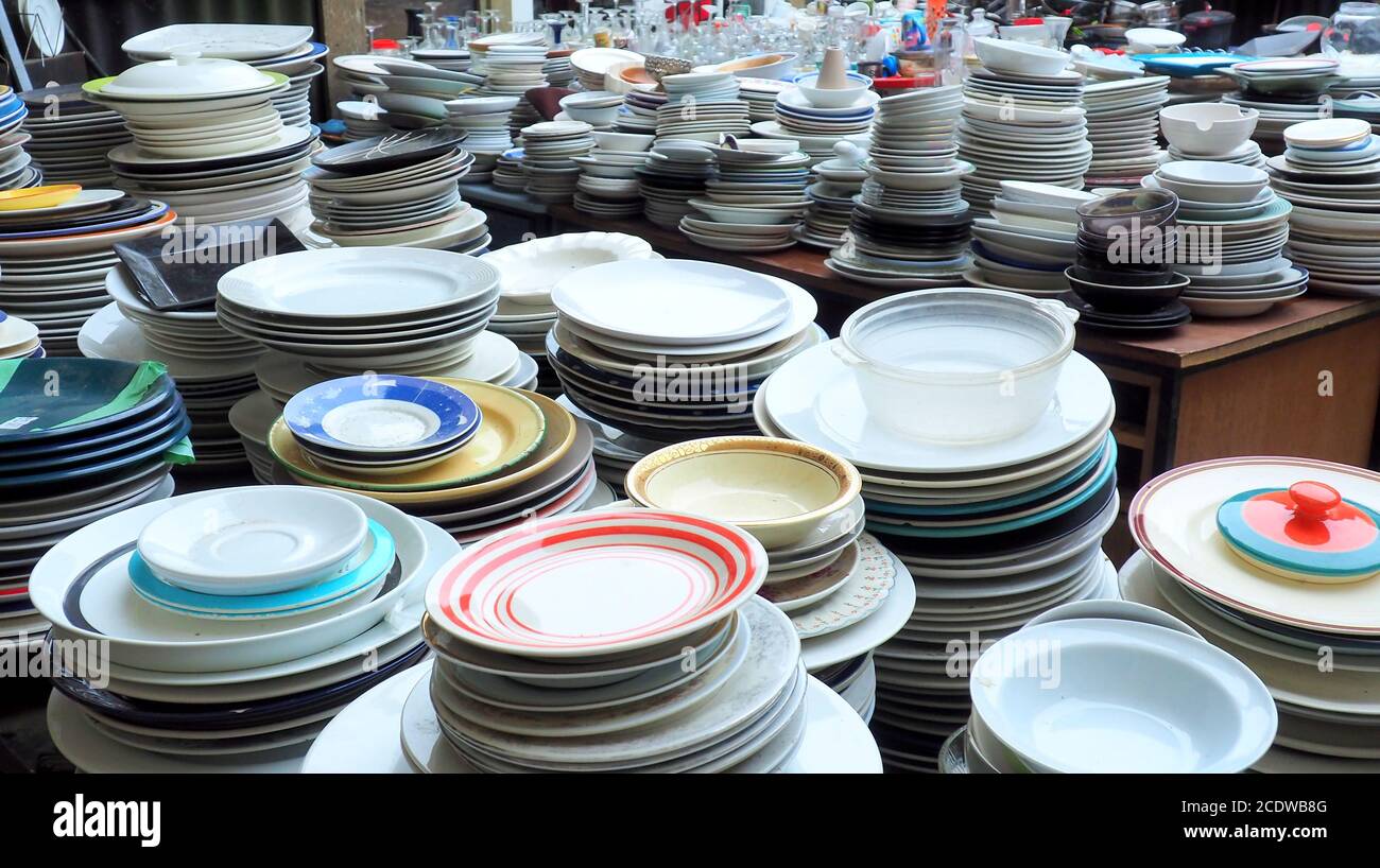 Cheap second hand white plates, stacked at Trash Palace, a junkyard for recycling household items Stock Photo