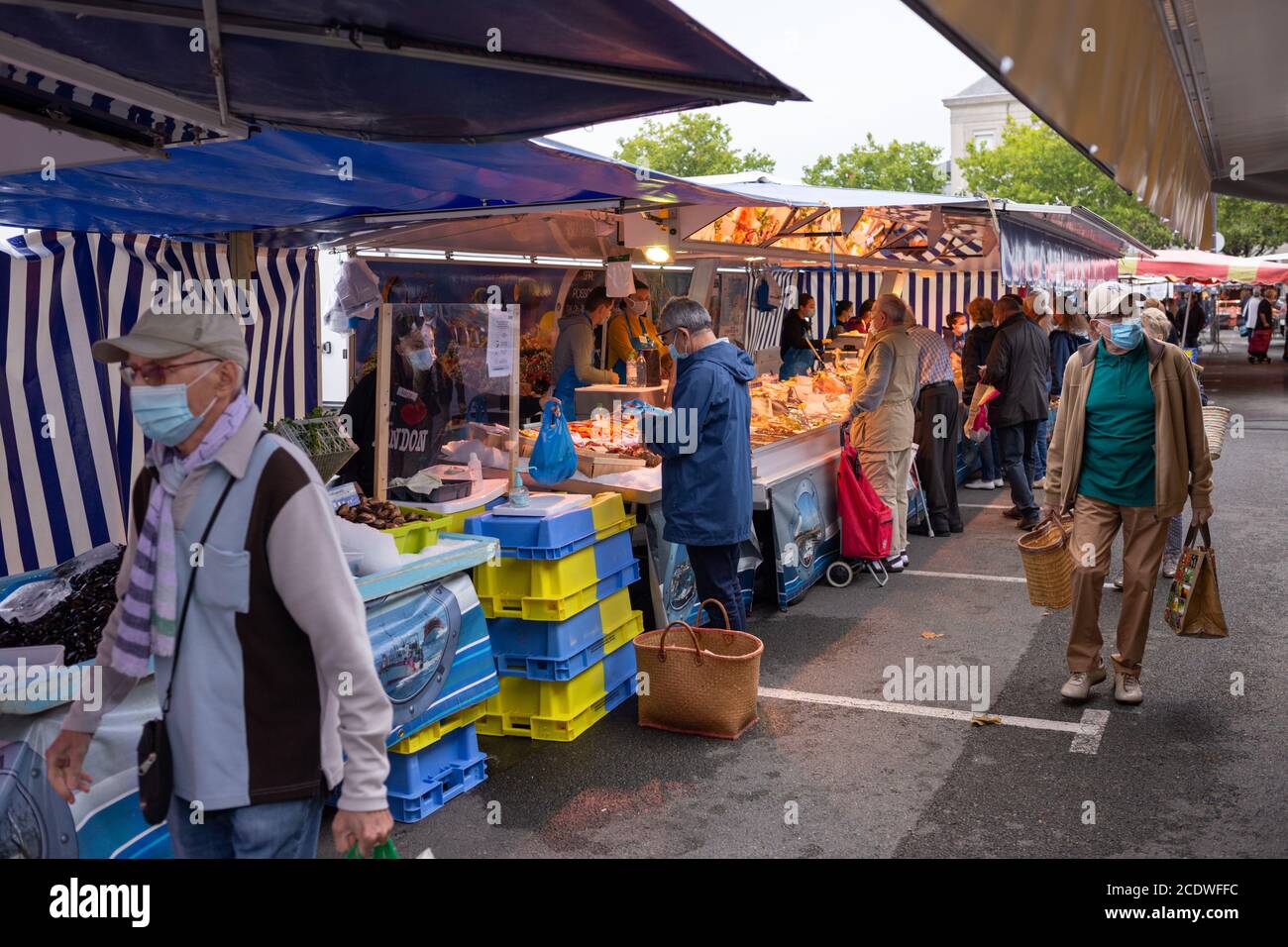 Angers, France - August 29 2020: people wearing face protective mask while shopping in the market place at France to prevent coronavirus, concept of wearing masks outdoor is mandatory, protection solutions, respect mask mode Stock Photo