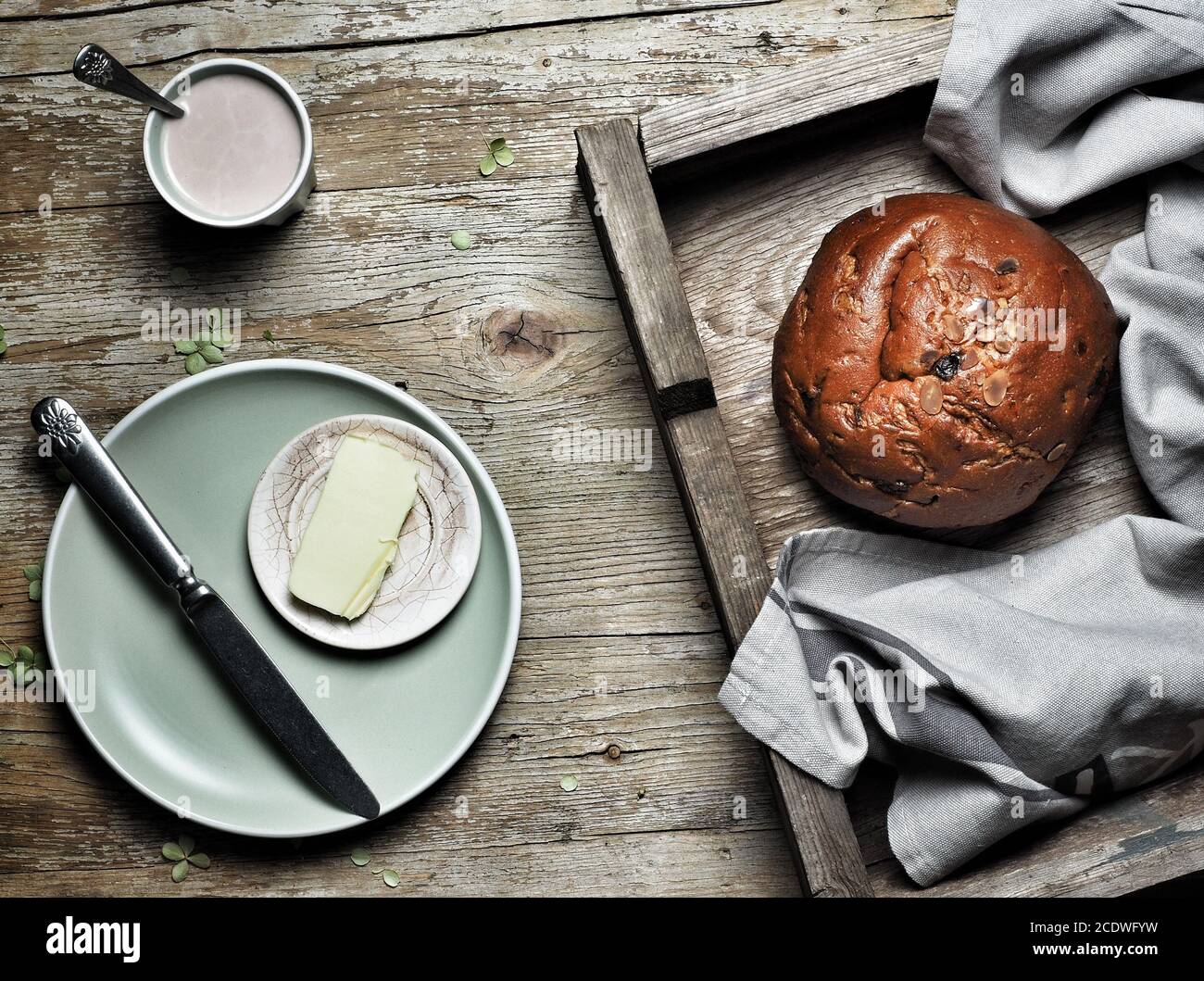 Sweet bread, typical Slovak cake. A cup of cocoa milk and piece of butter on plate on vintage wooden table. Overhead shot. Stock Photo