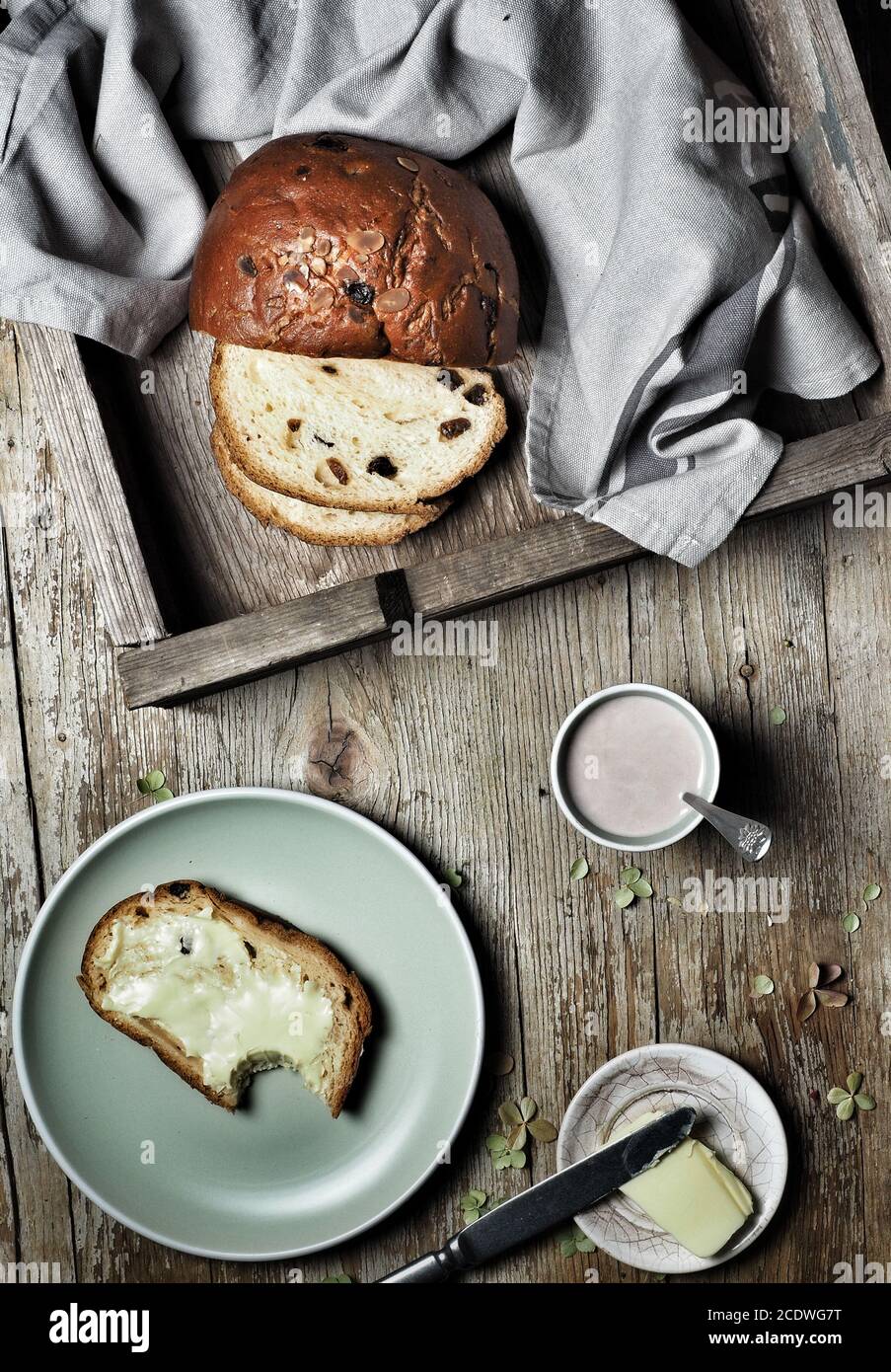 Sweet bread, typical Slovak cake. A cup of cocoa milk and piece of butter on plate on vintage wooden background. Overhead shot. Stock Photo