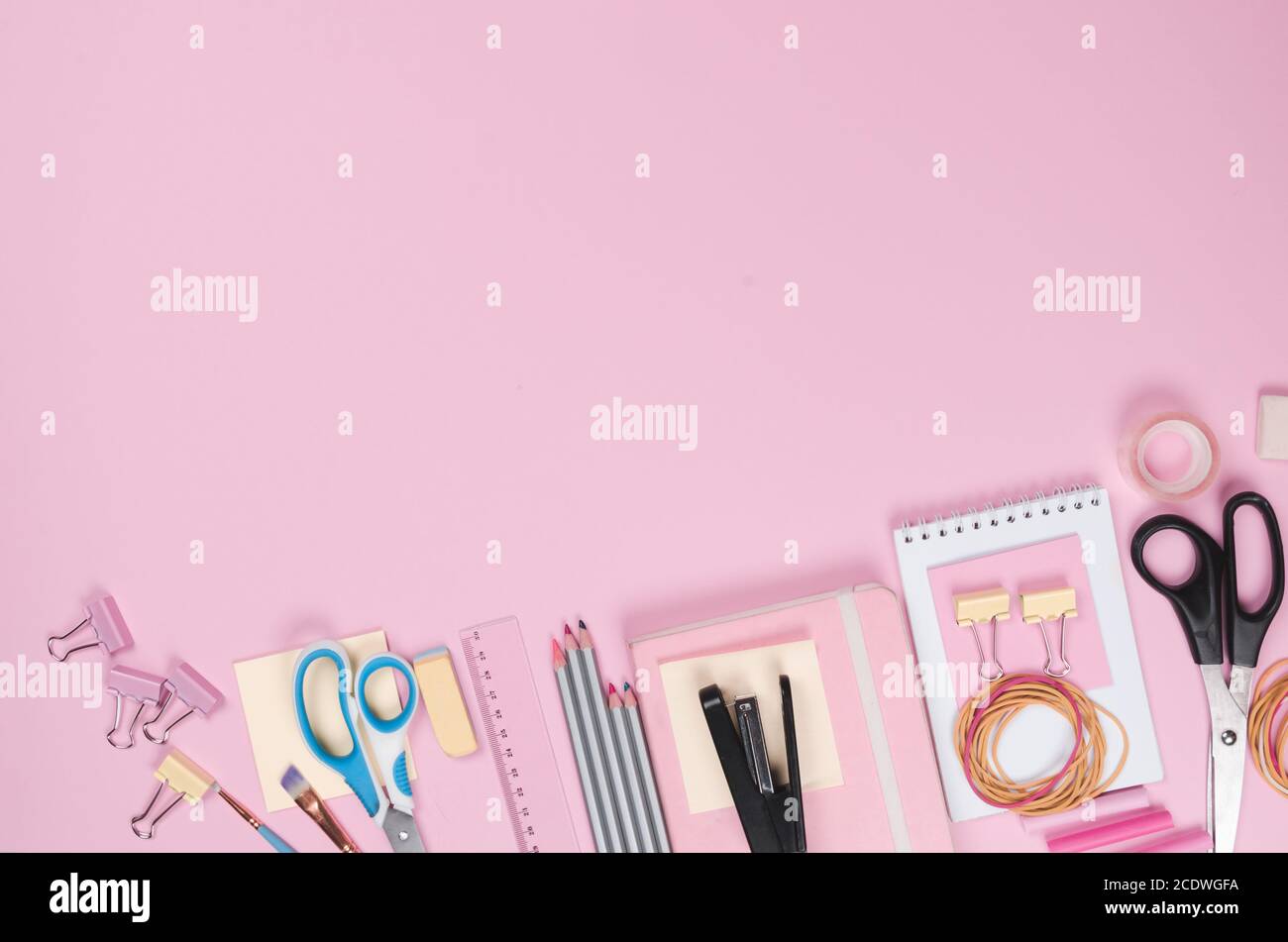 On a pink background, pink school supplies, a calculator, cheat
