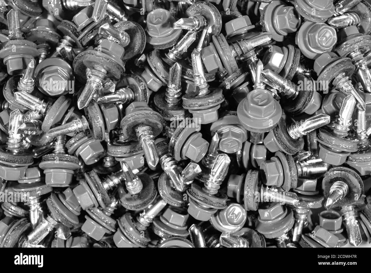Top view of roofing screws background texture. Roofing screws background. А bunch of self-tapping screws for fixing the roof Stock Photo