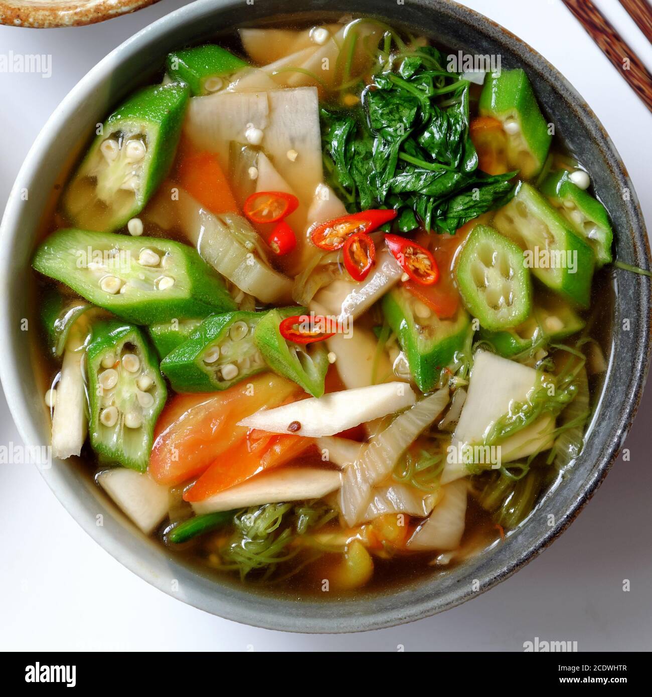 Top view sour vegetables soup bowl for vegan meal with simple food as tomato, bamboo shoot, okra, water spinach, vegetarian eating good for health Stock Photo