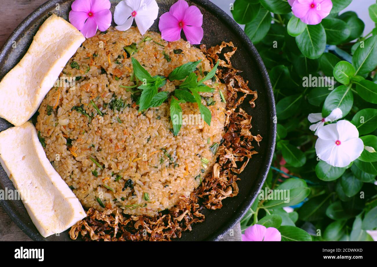 Vietnamese homemade food for lunch time, woman hand hold fried rice plate with tofu ready to eat, simple vegan food for vegetarian from high view Stock Photo
