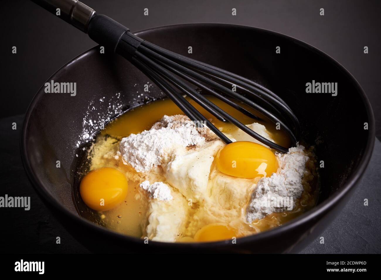 Mixing Bowl and Whisk with Eggs, Flour and Sugar Stock Photo