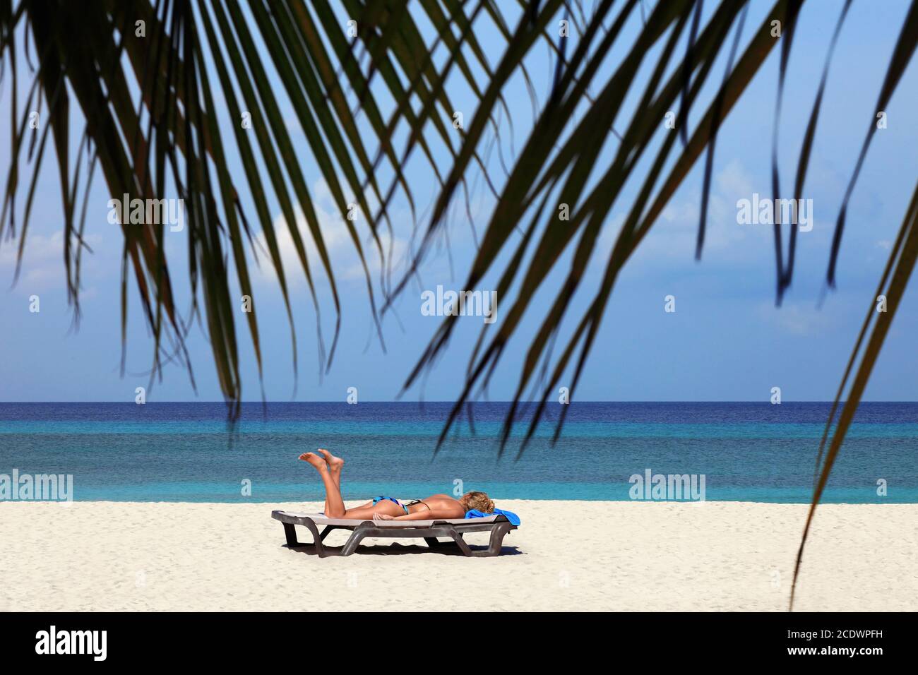 Tourist relaxing on the Maldivian beach. Stock Photo