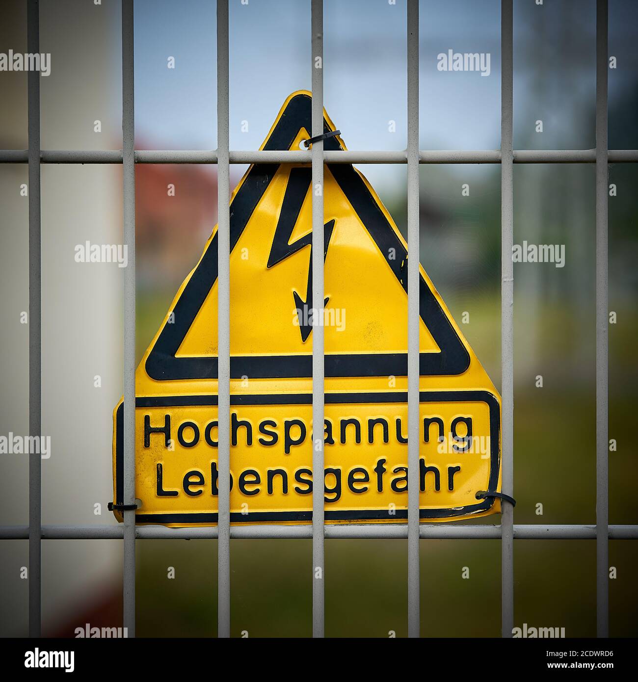 Sign with the inscription high voltage danger to life on a fence Stock Photo