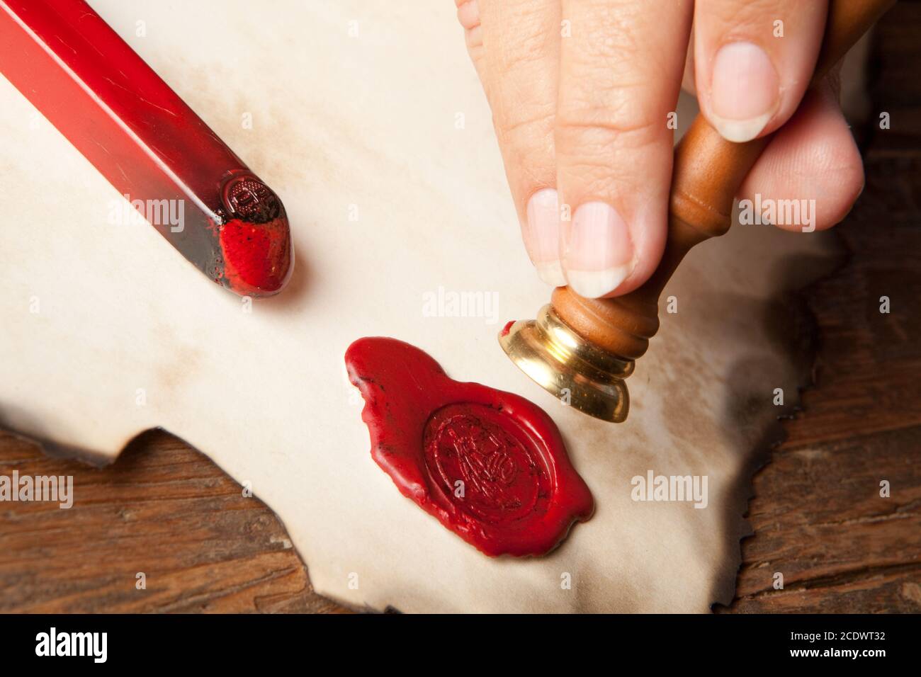 Hand with ancient parchment or diploma scroll with wax seal Stock Photo