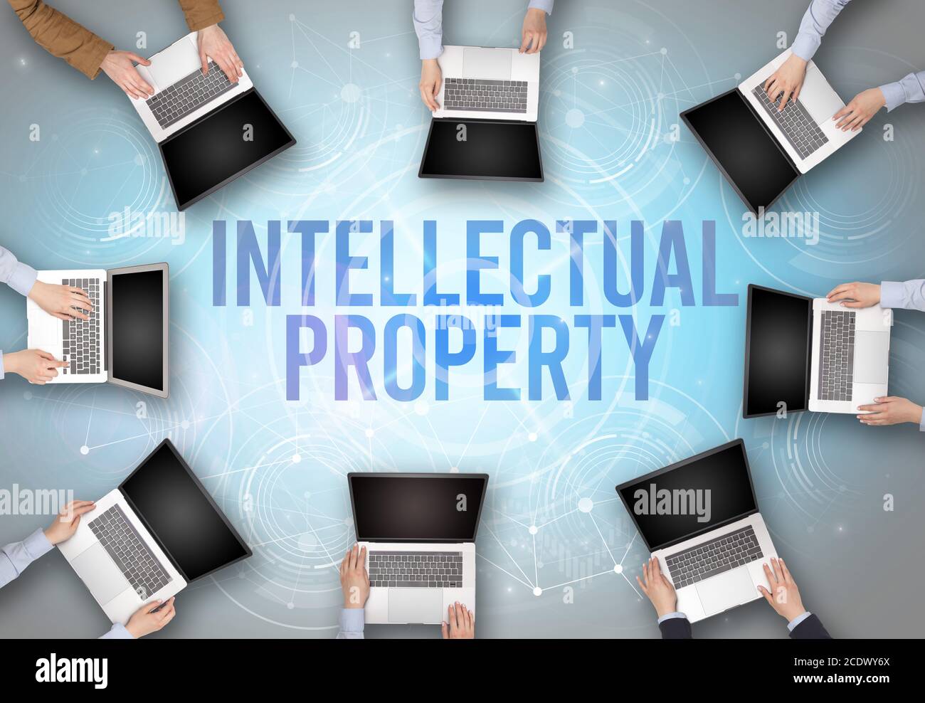 Group of people in front of a laptop with INTELLECTUAL PROPERTY insciption, web security concept Stock Photo