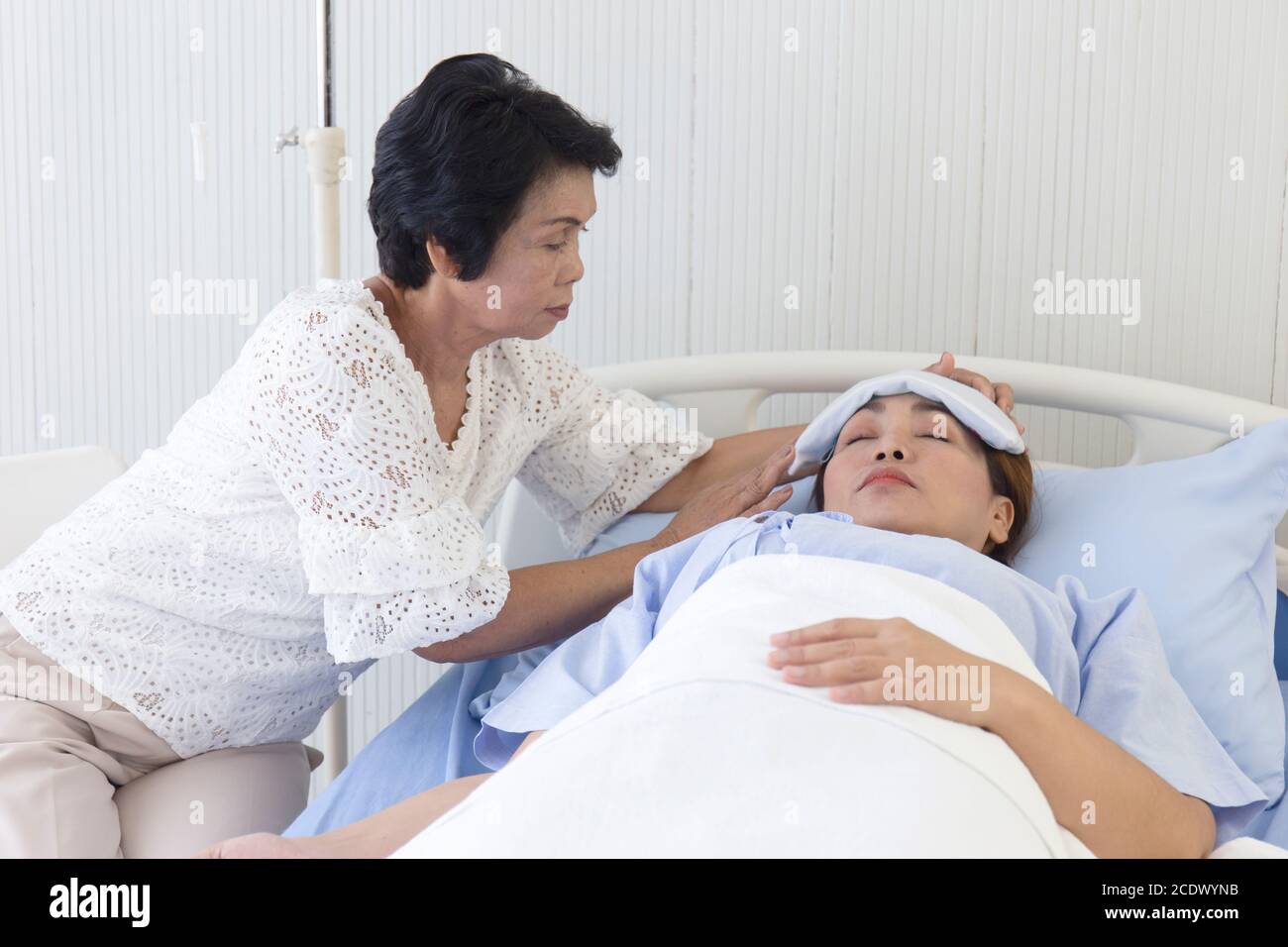 An Asian mother takes care of her sick daughter on a hospital bed Stock ...