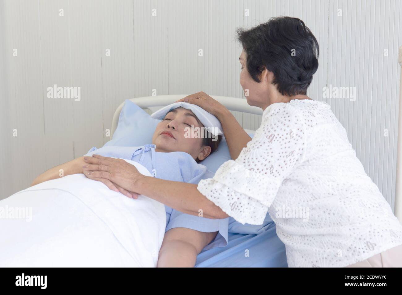 An Asian mother takes care of her sick daughter on a hospital bed Stock ...