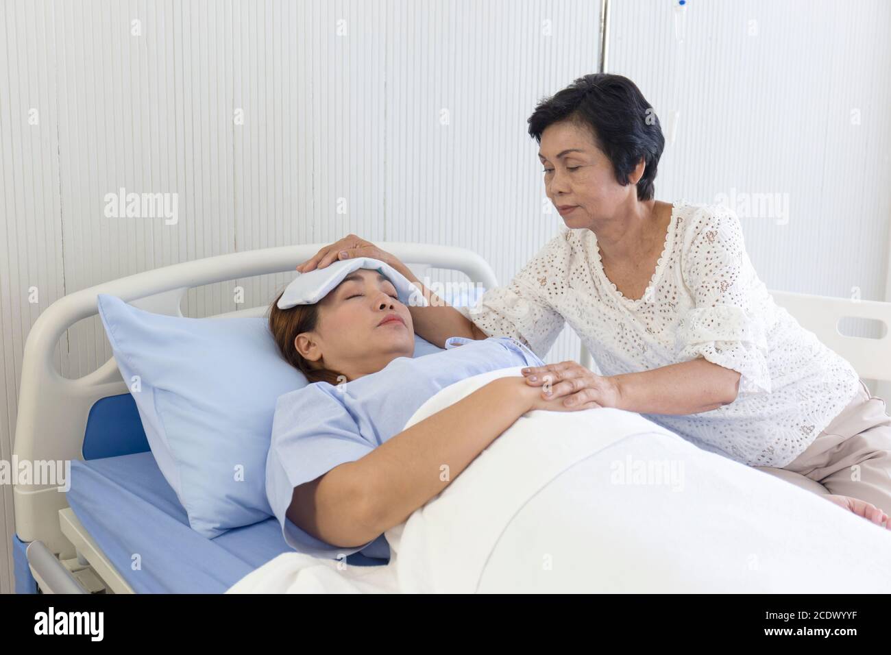An Asian mother takes care of her sick daughter on a hospital bed Stock ...