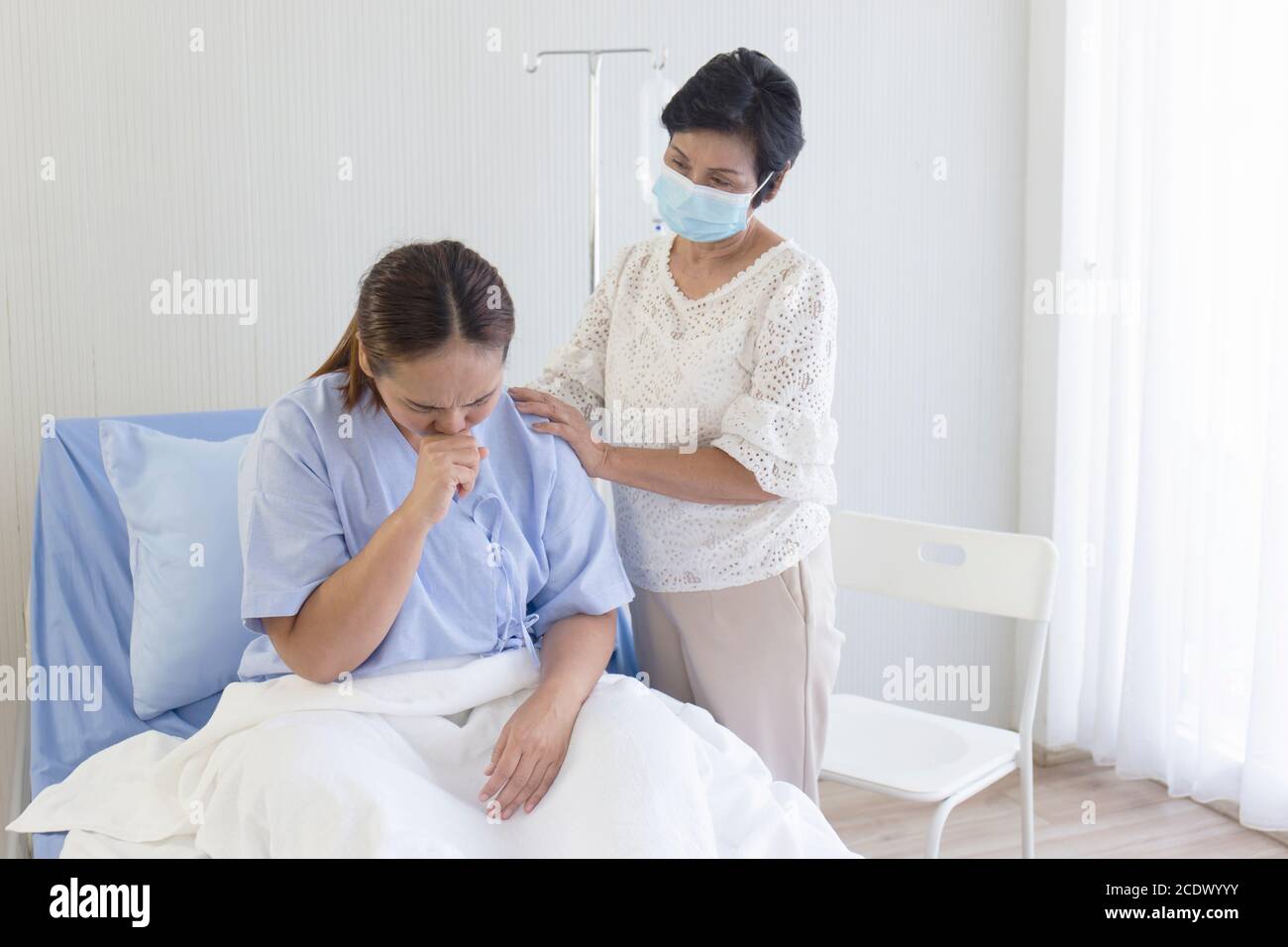 An Asian mother takes care of her sick daughter on a hospital bed Stock ...