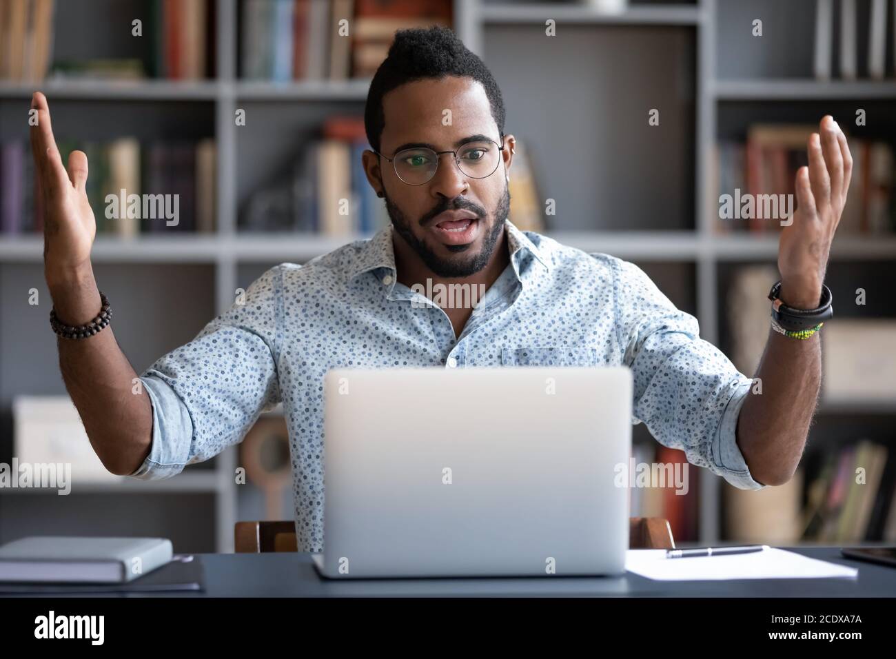 Irritated angry African American man having problem with laptop Stock Photo