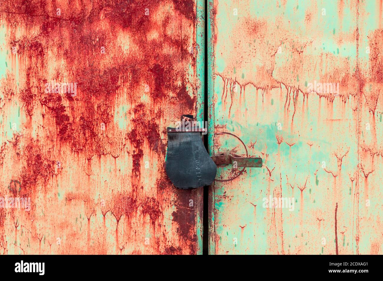 Close up of padlock and old metal hasp and staple on an rusty metal door Stock Photo