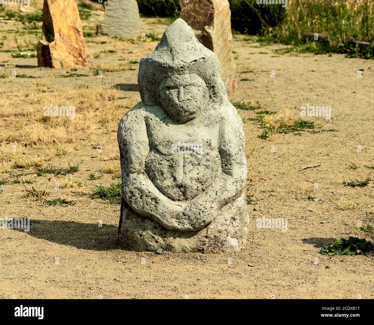 A stone anthropomorphic statue in a clearing. Stock Photo