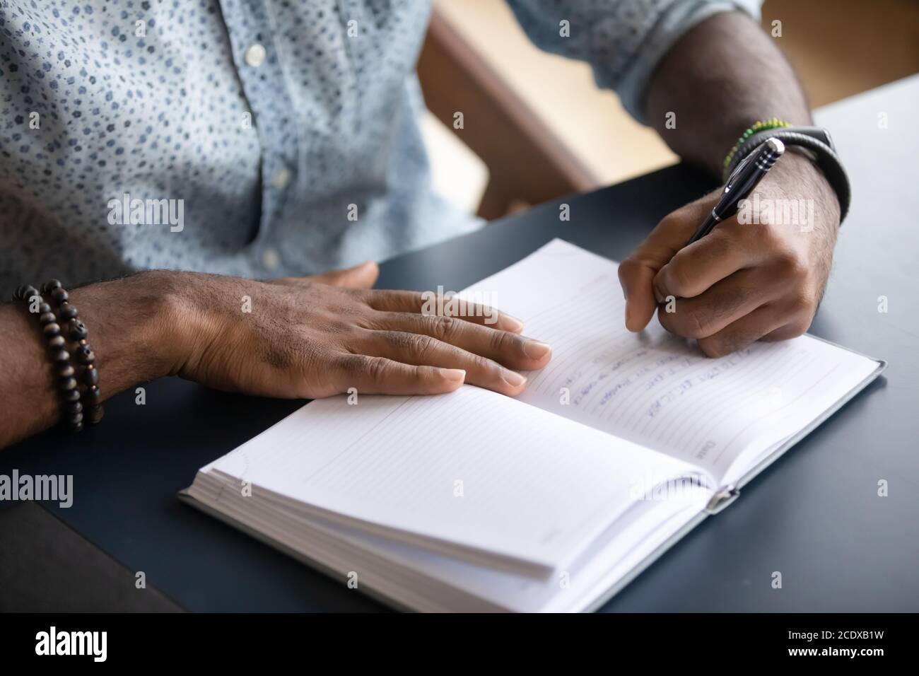 Close up African American businessman writing in notebook, making notes Stock Photo