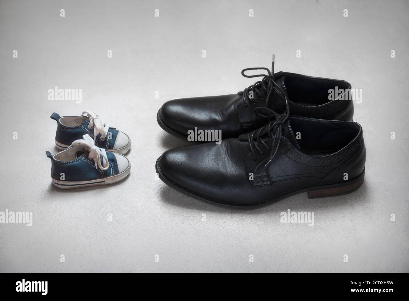 Father with son Metaphor, baby and adult shoes Stock Photo