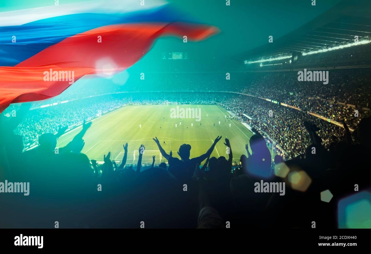 Crowded football stadium with lens-flare and russian flag. Stock Photo