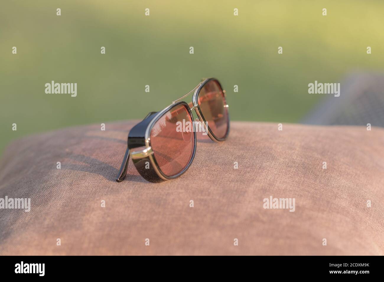 Retro sunglasses model with red lenses shoot in a summer day closeup. Selective focus Stock Photo