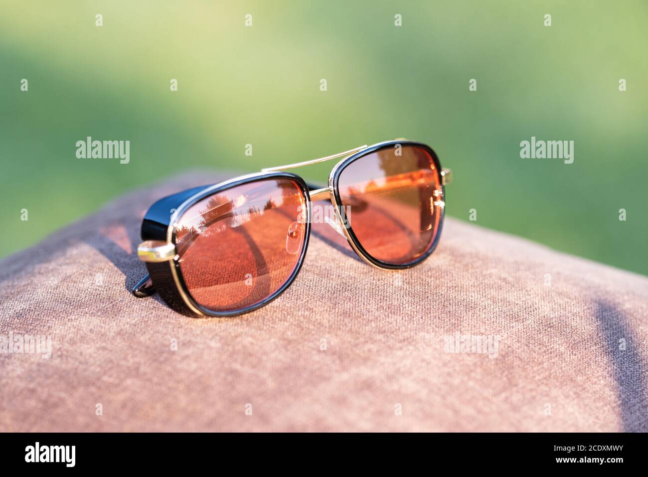 Retro sunglasses model with red lenses shoot in a summer day closeup. Selective focus Stock Photo