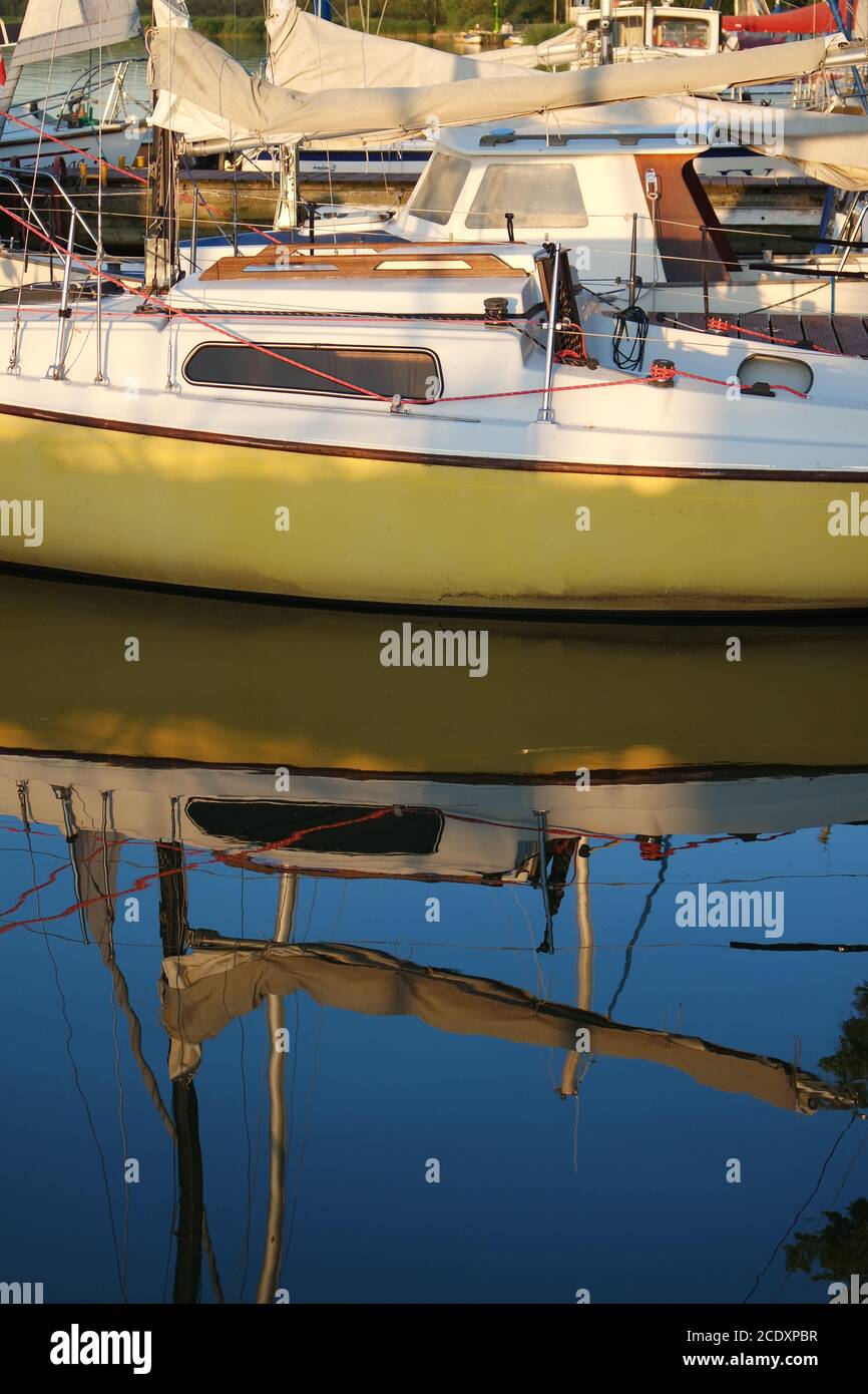 Sailboat is reflected in the water Stock Photo - Alamy