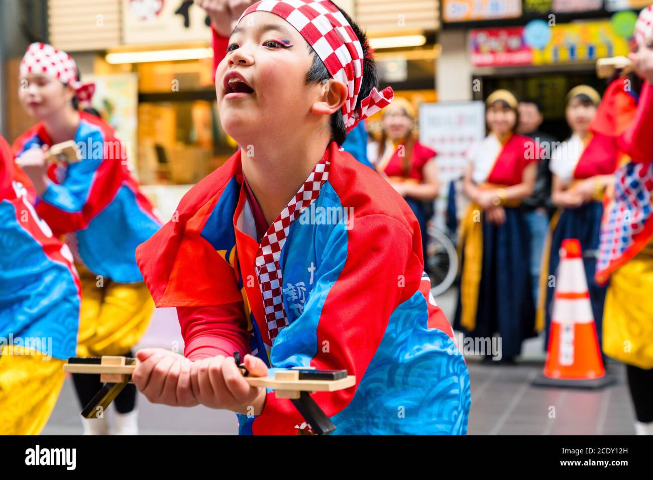 Japanese child, boy, 7-9 year old, dancer in Yosakoi dance team, dancing with naruko, wooden clappers, in front of viewer at Kyusyu Gassai festival. Stock Photo