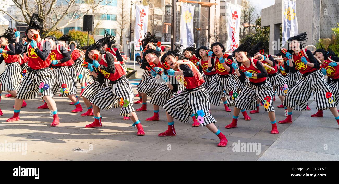 Team of Japanese child yosakoi dancers dancing while using naruko, wooden clappers, during the Kumamoto Kyusyu Gassai dance festival in Japan. Stock Photo