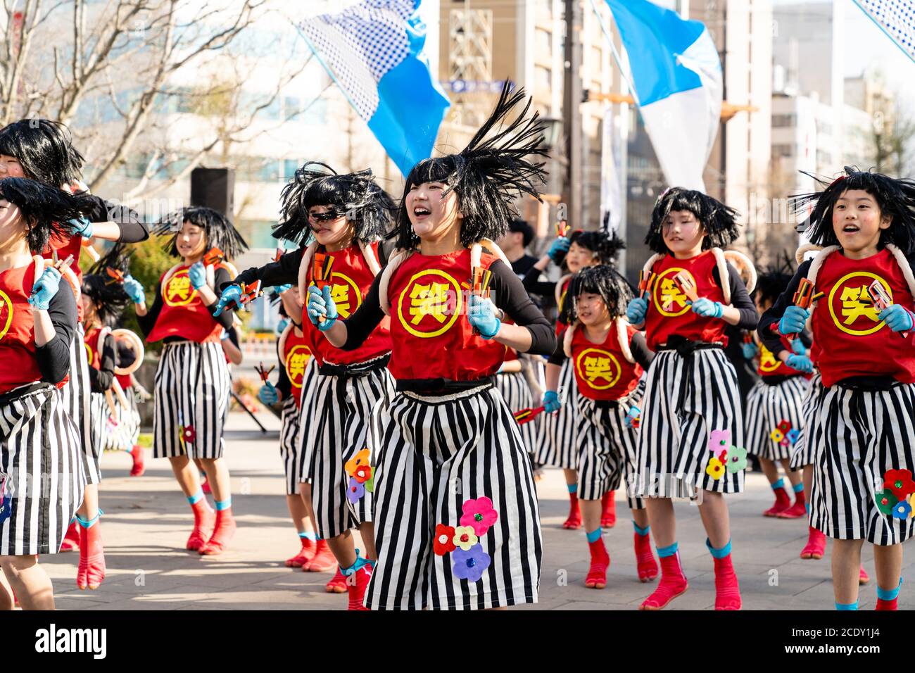 Team of Japanese child yosakoi dancers dancing while using naruko, wooden clappers, during the Kumamoto Kyusyu Gassai dance festival in Japan. Stock Photo