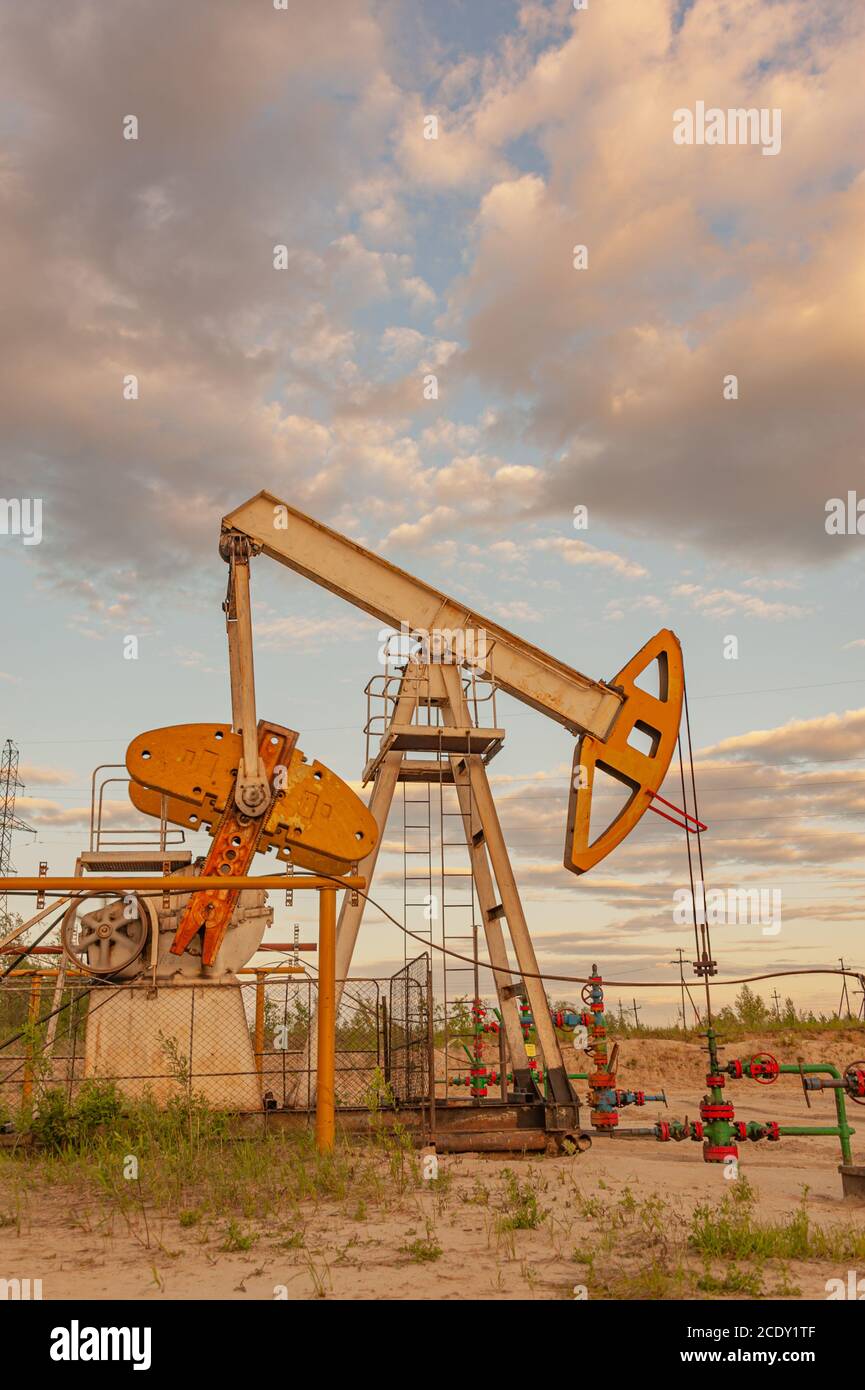 Petroleum concept. Oil pump rig. Oil and gas production. Oilfield site. Pump Jack are running. Drilling derricks for fossil fuel Stock Photo