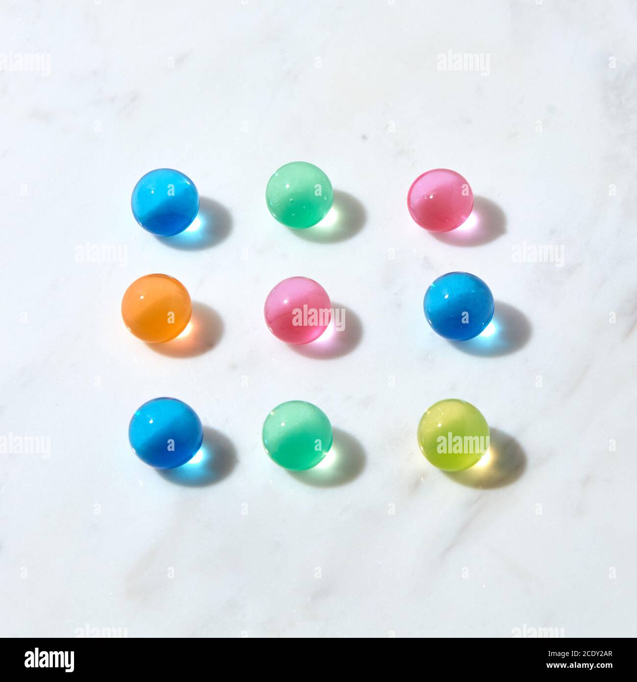 Square pattern from hydrogel colored balls on a grey marble table. Stock Photo