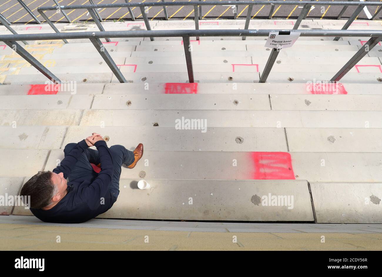 A spectator arrives at the stands, marked out with red squares, during